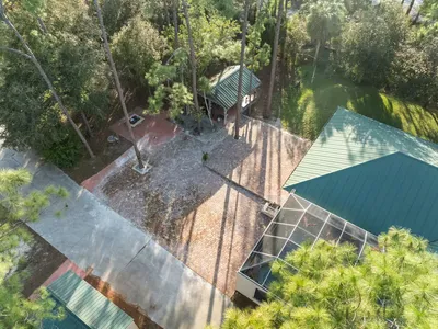Backyard surrounded by trees and cobblestones